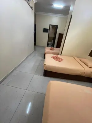 a room with two beds and a mirror at Makkah Hotel in Qena