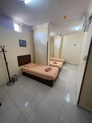 a room with two beds and a television in it at Makkah Hotel in Qena