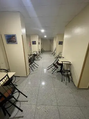 a row of tables and chairs in a hallway at Makkah Hotel in Qena