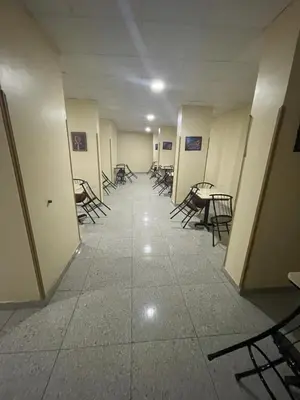 a hallway with chairs and tables in a building at Makkah Hotel in Qena