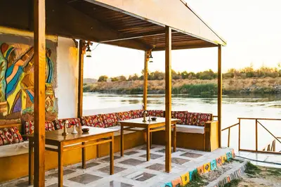 a restaurant with two tables and a view of a river at Fenti Nubian Resort in Aswan