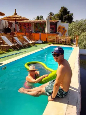 two men sitting in the water in a swimming pool at Fenti Nubian Resort in Aswan