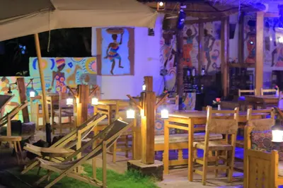 a restaurant with wooden tables and chairs with candles at Fenti Nubian Resort in Aswan