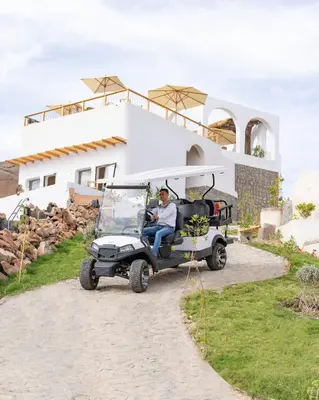 a man sitting in a golf cart in front of a house at Benben by Dhara Hotels - Adults Only in Aswan