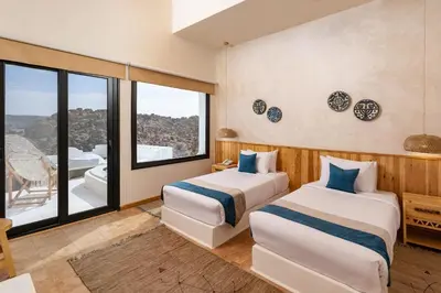 two beds in a room with a large window at Benben by Dhara Hotels - Adults Only in Aswan