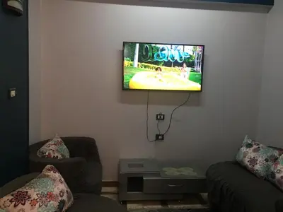 a living room with a flat screen tv on the wall at Babylon guesthouse in Aswan
