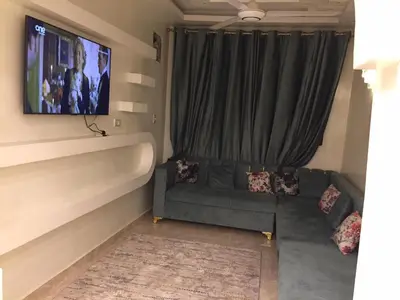 a living room with a couch and a flat screen tv at Babylon guesthouse in Aswan