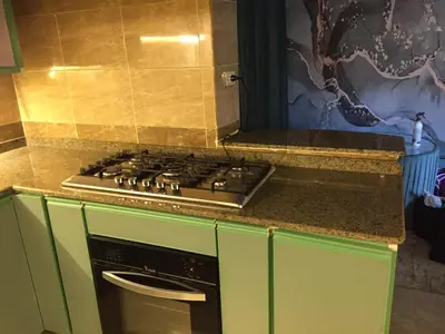 a stove top in a kitchen with green cabinets at Babylon guesthouse in Aswan