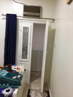 a room with a door and a window with a fan at Babylon guesthouse in Aswan
