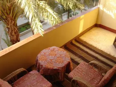 an empty room with chairs and a table and a palm tree at Rose Guest House \u60a8\u5728\u76e7\u514b\u7d22\u7684\u7b2c\u4e8c\u500b\u5bb6 in Luxor