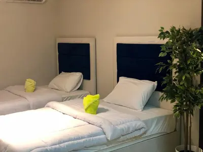 two beds in a room with white sheets and yellow pillows at Villa KUBA luxury private pool 2 in Hurghada