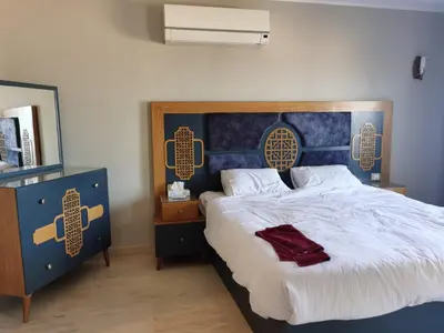 a bedroom with a large bed with a blue headboard at Villa KUBA luxury private pool 2 in Hurghada