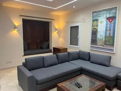 a living room with a blue couch and a table at El Gouna abo tig marina 1 bedroom apartment and 1 bedroom at the Roof in Hurghada