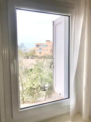 an open window with a view of a tree at El Gouna abo tig marina 1 bedroom apartment and 1 bedroom at the Roof in Hurghada