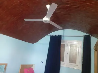 a ceiling fan in a room with a mirror at Nubia castle in Aswan