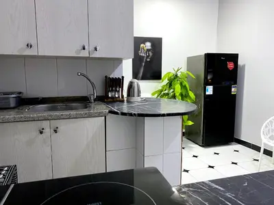 a kitchen with a sink and a black refrigerator at Lima Modern. Sea View. Strong Wi Fi. Sheraton Road in Hurghada