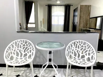 two white chairs and a table and a stool at Lima Modern. Sea View. Strong Wi Fi. Sheraton Road in Hurghada