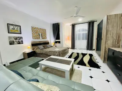 a living room with a couch and a table at Lima Modern. Sea View. Strong Wi Fi. Sheraton Road in Hurghada