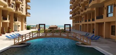 a wooden bridge over a pool of water with chairs at Tertels beach resort hurghada F 2-6 in Hurghada