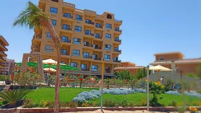 a large yellow building with a garden in front of it at Tertels beach resort hurghada F 2-6 in Hurghada