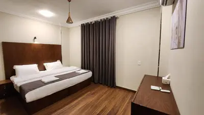 a hotel room with a bed and a desk at Sphinx Luxor Apartment in Luxor