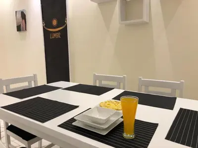 a table with a plate of food and a glass of beer at Sphinx Luxor Apartment in Luxor