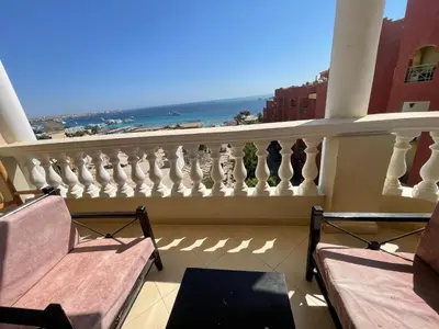 a balcony with two chairs and a view of the ocean at Marvel flat in Hurghada