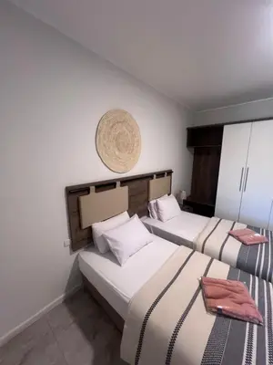 a bedroom with two beds and a basket on the wall at Boho Homes in Hurghada