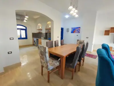 a dining room with a wooden table and chairs at Amaros Sahl Hasheesh sea view Villa with Pool سهل حشيش in Hurghada