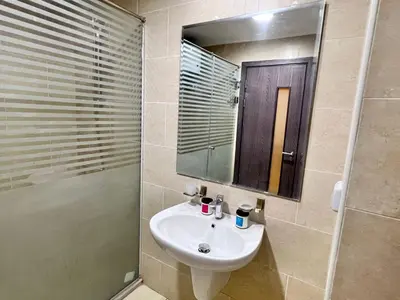 a bathroom with a sink and a shower and a mirror at AlDAU Heights Modern Brand New Apartments in Hurghada
