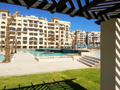 a large apartment building with a pool in front of it at AlDAU Heights Modern Brand New Apartments in Hurghada