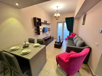 a living room with a couch and a dining room at AlDAU Heights Modern Brand New Apartments in Hurghada