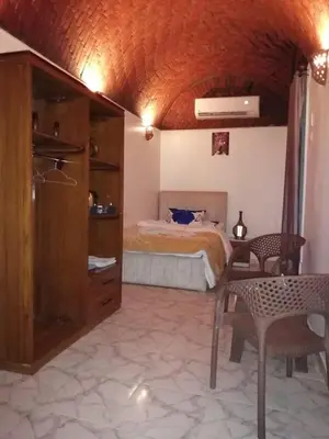 a bedroom with a bed and a table and chairs at Go Inn Backpackers in Aswan