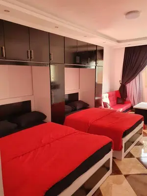 two beds in a room with red sheets at 304 الشيراتون بلازا in Hurghada