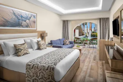 a bedroom with a bed and a living room at Beach Albatros The Club - Aqua Park in Hurghada