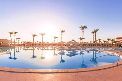 a large pool at a resort with palm trees at Beach Albatros The Club - Aqua Park in Hurghada