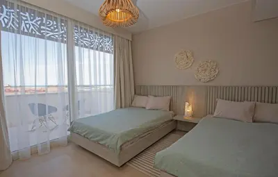 a bedroom with two beds and a large window at A Stunning Seaview Penthouse; 3bedrooms + nanny in Hurghada