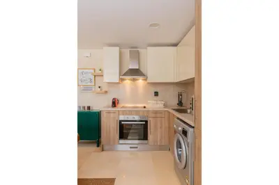 a kitchen with white cabinets and a dishwasher at Balanced & Bright 2 BDR Mangroovy Free Pool & Beach Access in Hurghada
