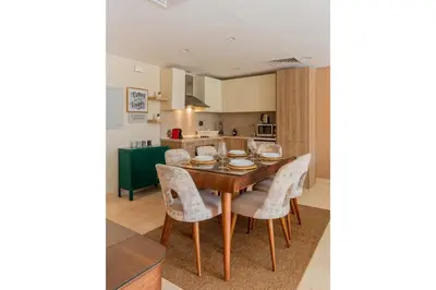 a kitchen and dining room with a wooden table and chairs at Balanced & Bright 2 BDR Mangroovy Free Pool & Beach Access in Hurghada