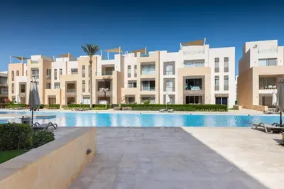 a swimming pool in front of a large building at Balanced & Bright 2 BDR Mangroovy Free Pool & Beach Access in Hurghada