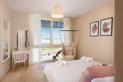 a bedroom with a bed with a swing and a window at Chilled & Serene 1BDR Mangroovy Pool & Sea View in Hurghada