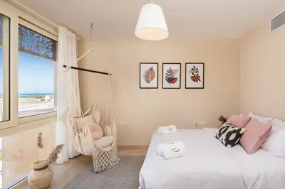 a bedroom with a swinging bed and a window at Chilled & Serene 1BDR Mangroovy Pool & Sea View in Hurghada