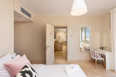 a bedroom with a bed and a table and a desk at Chilled & Serene 1BDR Mangroovy Pool & Sea View in Hurghada