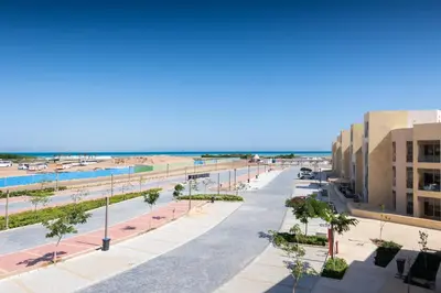 a street in front of a beach with buildings at Chilled & Serene 1BDR Mangroovy Pool & Sea View in Hurghada