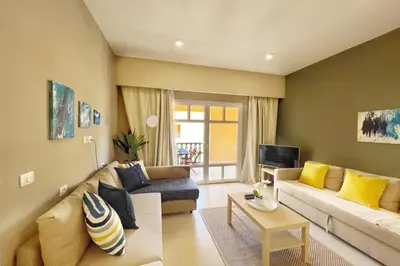 a living room with a couch and a tv at Minimal & Central 1BDR Apt Abu Tig Marina in Hurghada