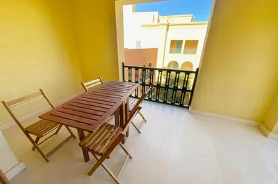a wooden table and chairs on a balcony at Minimal & Central 1BDR Apt Abu Tig Marina in Hurghada
