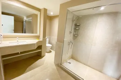 a bathroom with a shower and a sink and a mirror at Minimal & Central 1BDR Apt Abu Tig Marina in Hurghada