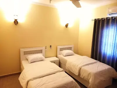 two twin beds in a room with a window at Embrace Guest House in Luxor