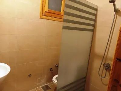 a bathroom with a shower with a toilet and a sink at Embrace Guest House in Luxor