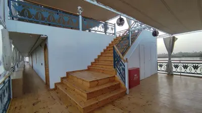 a staircase in a building with wooden floors and a railing at Embrace 1 Nile Sailing Dahabiya in Luxor